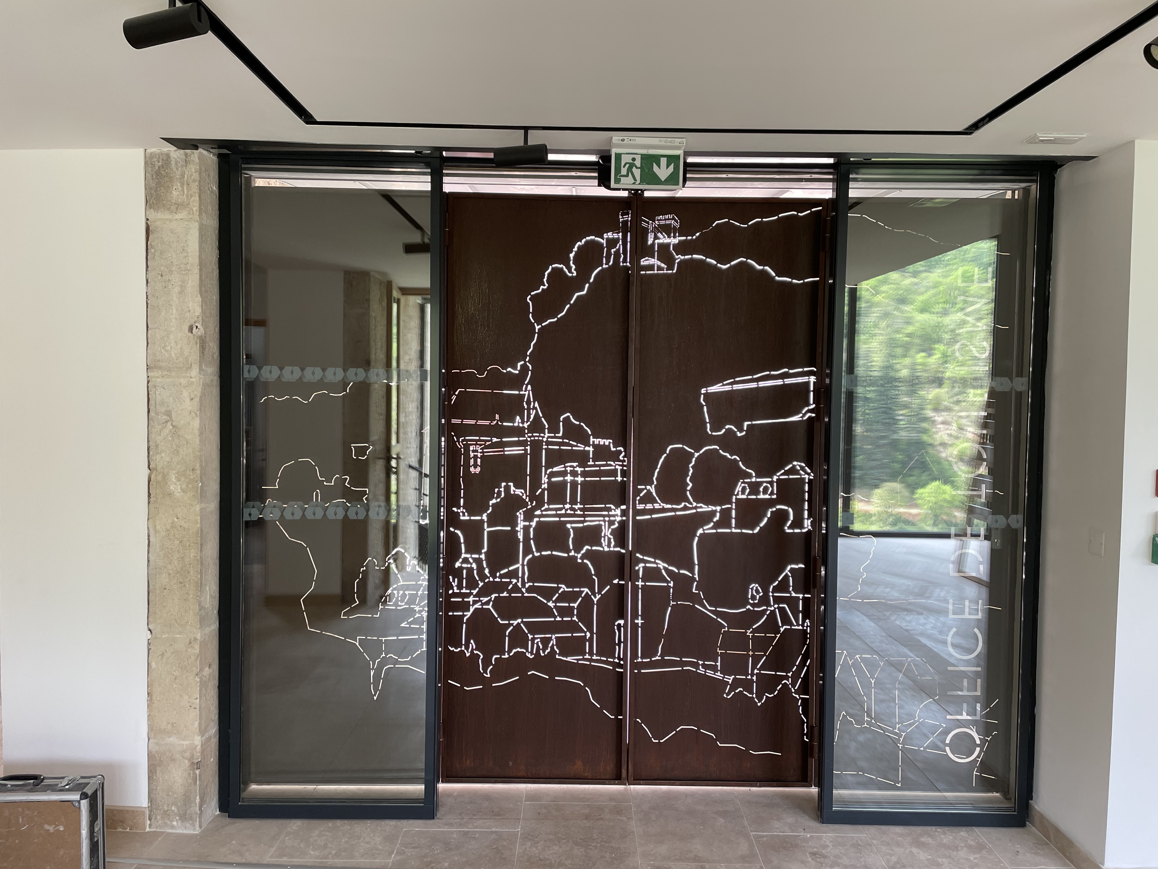Portes intérieures avec motif cartographique : Vue depuis l'intérieur de la porte d'entrée avec sa découpe précise figurant les contours de la cité.
