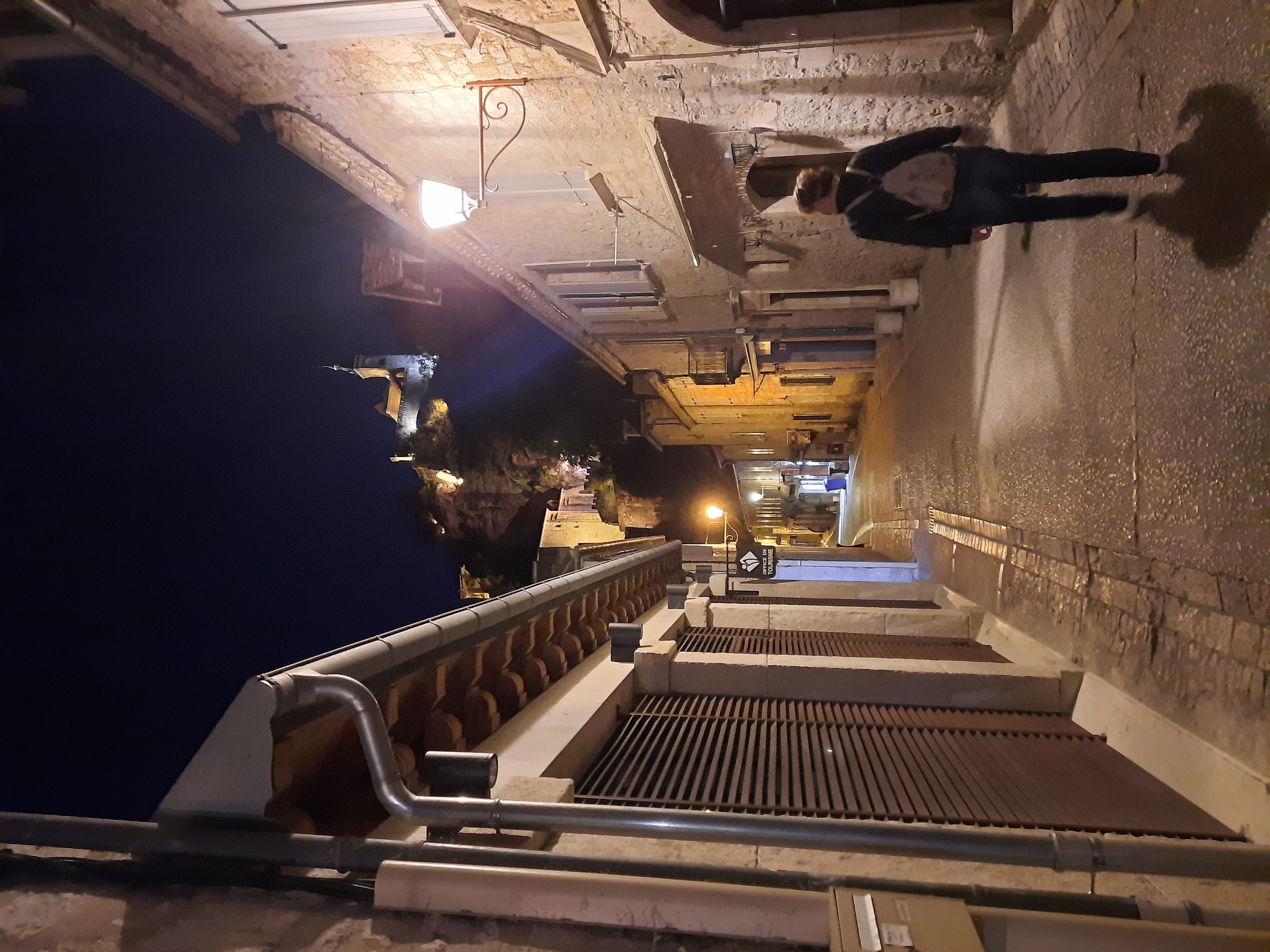 Vue nocturne de la rue médiévale : La cité de Rocamadour illuminée, avec en arrière-plan le sanctuaire perché sur la falaise.